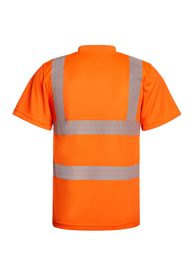 Erwachsener Bauarbeiter steht in gelbem Korntex Warnschutz-T-Shirt mit reflektierenden Streifen und Schutzhelm vor einem verfallenem Gebäude
