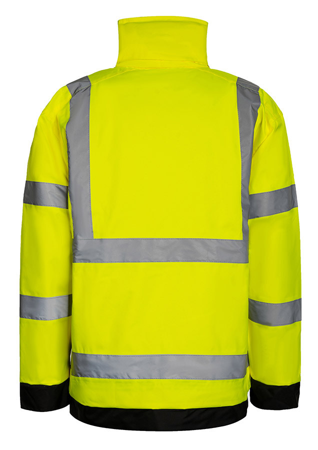 Erwachsener Bauarbeiter in gelber Korntex Hochsichtbarkeits-Regenjacke und gelbem Schutzhelm trägt eine Schaufel auf einer Baustelle.